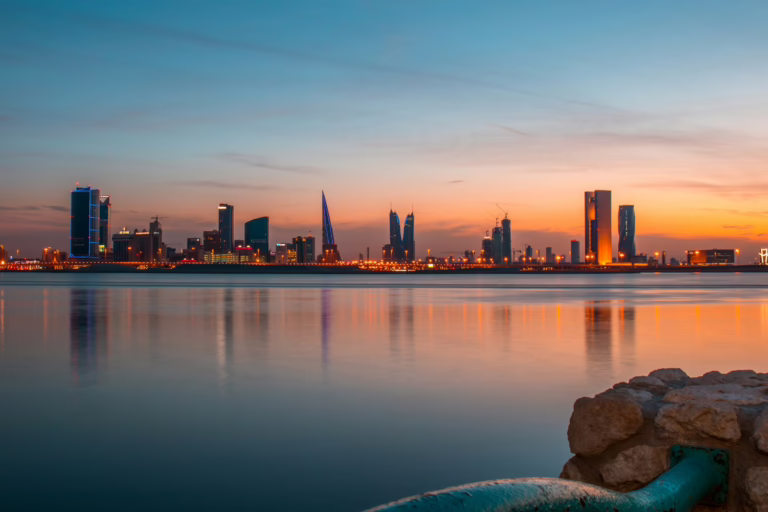 Manama skyline at sunset reflected on the water, Bahrain