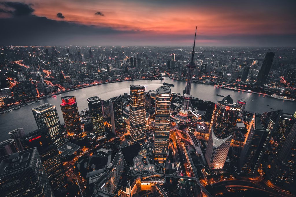 Aerial dusk view of Shanghai Lujiazui skyline and Oriental Pearl Tower across the Huangpu River